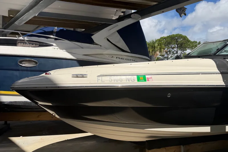 Slide: The Image of 2006 Sea Ray 240 Sundeck boat docked, side view with registration visible. - 4