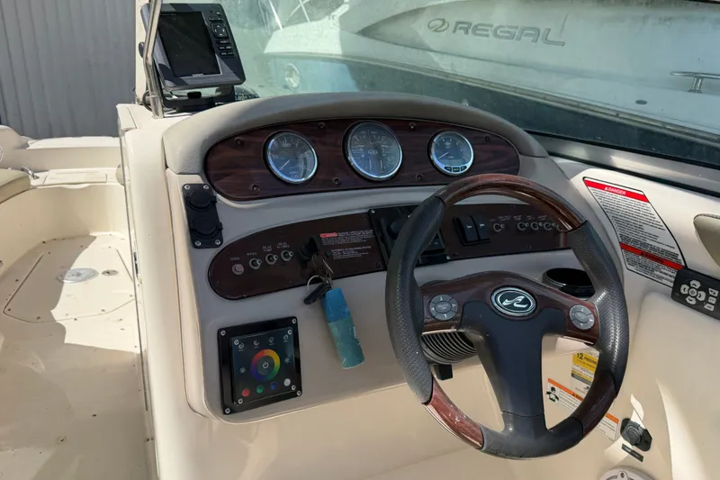 Slide: The Image of 2006 Sea Ray 240 Sundeck dashboard with steering wheel and gauges. - 20