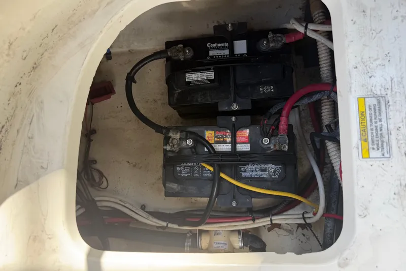 Slide: The Image of Battery compartment of a 2006 Sea Ray 240 Sundeck with wiring and caution label. - 37