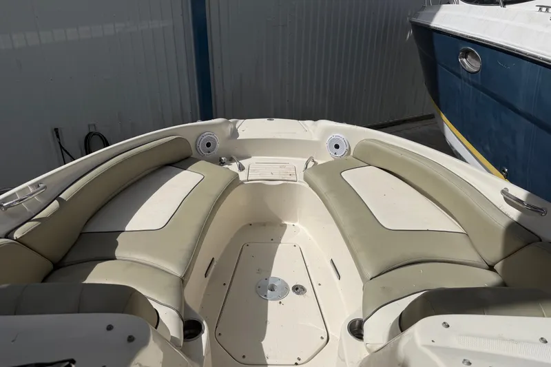 Slide: The Image of 2006 Sea Ray 240 Sundeck boat interior with beige seating and storage compartments. - 46