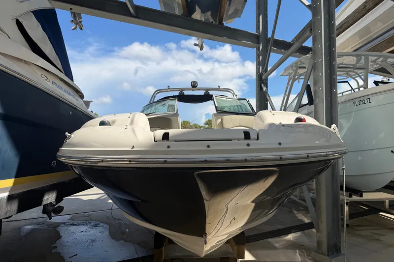 Slide: The Image of 2006 Sea Ray 240 Sundeck boat in storage, surrounded by other vessels. - 1