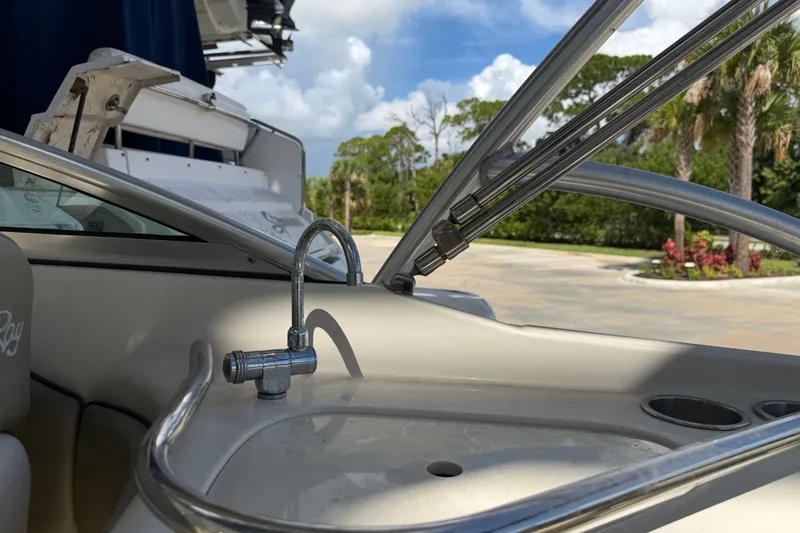 Slide: The Image of 2006 Sea Ray 240 Sundeck boat interior with sink and faucet, sunny day background. - 29