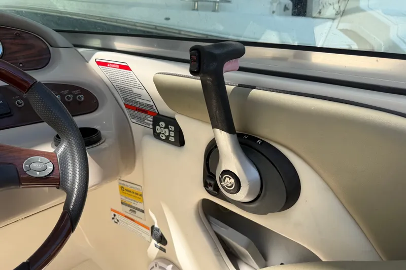 Slide: The Image of 2006 Sea Ray 240 Sundeck throttle control and steering wheel detail. - 26