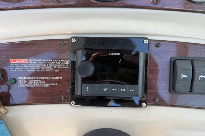 Slide: The Image of Control panel of a 2006 Sea Ray 240 Sundeck with warning labels and audio system. - 24
