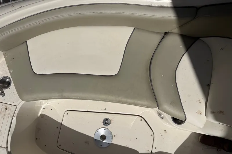Slide: The Image of Interior seating of a 2006 Sea Ray 240 Sundeck boat, featuring beige upholstery. - 49