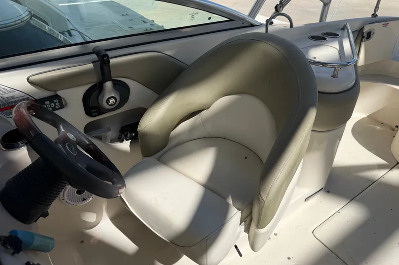 Slide: The Image of Interior of a 2006 Sea Ray 240 Sundeck boat, featuring steering wheel and seating. - 18