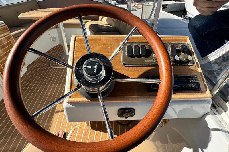 Slide: The Image of Steering wheel of a 2008 Duffy Snug Harbor boat with control panel. - 11