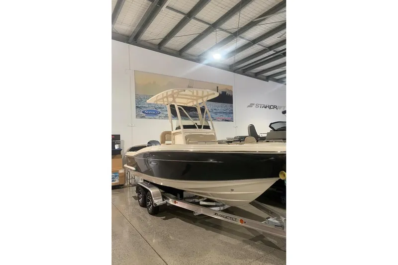 The Image of 2022 Scout 215 XSF boat on trailer in showroom setting. - 1