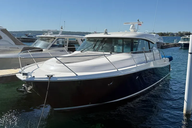 Slide: The Image of 2019 Tiara Yachts C44 Coupe docked in a marina under clear blue skies. - 0