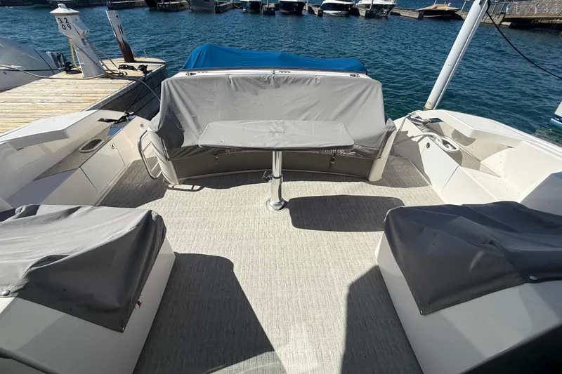 Slide: The Image of 2019 Tiara Yachts C44 Coupe cockpit with covered seating and table, docked by the water. - 10