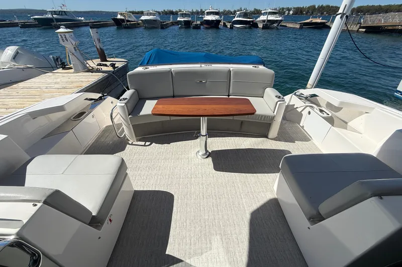 Slide: The Image of 2019 Tiara Yachts C44 Coupe cockpit with seating and table, docked at marina. - 12