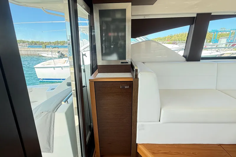 Slide: The Image of Interior of 2019 Tiara Yachts C44 Coupe with white seating and wooden cabinetry. - 22