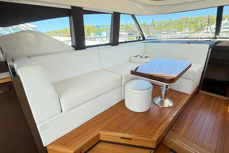 Slide: The Image of Luxurious interior of 2019 Tiara Yachts C44 Coupe with white seating and wooden table. - 24