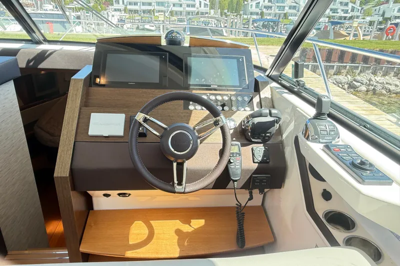 Slide: The Image of 2019 Tiara Yachts C44 Coupe helm with modern navigation controls and steering wheel. - 25