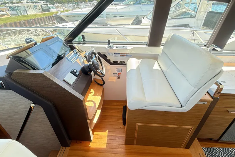 Slide: The Image of Helm station of 2019 Tiara Yachts C44 Coupe with modern controls and white seating. - 27