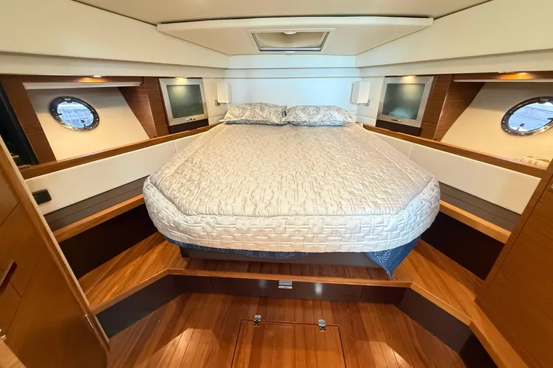 Slide: The Image of Luxurious 2019 Tiara Yachts C44 Coupe cabin with elegant bedding and wood accents. - 29