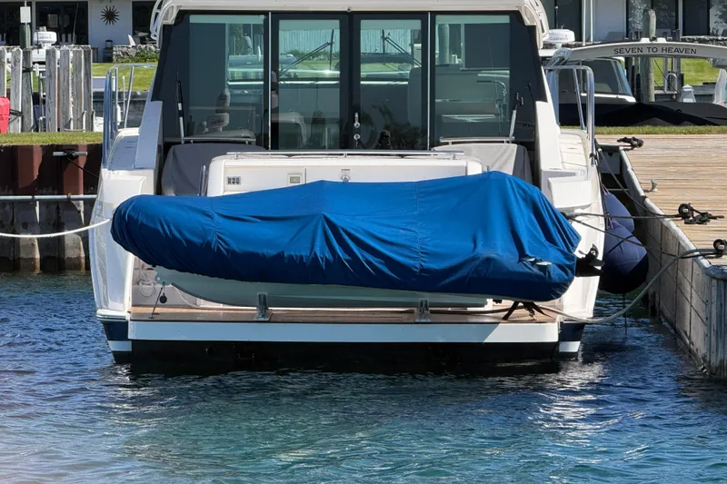 Slide: The Image of 2019 Tiara Yachts C44 Coupe docked with covered tender at marina. - 3