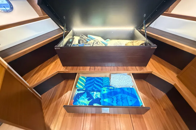 Slide: The Image of Storage compartments in 2019 Tiara Yachts C44 Coupe, featuring organized towels and gear. - 30