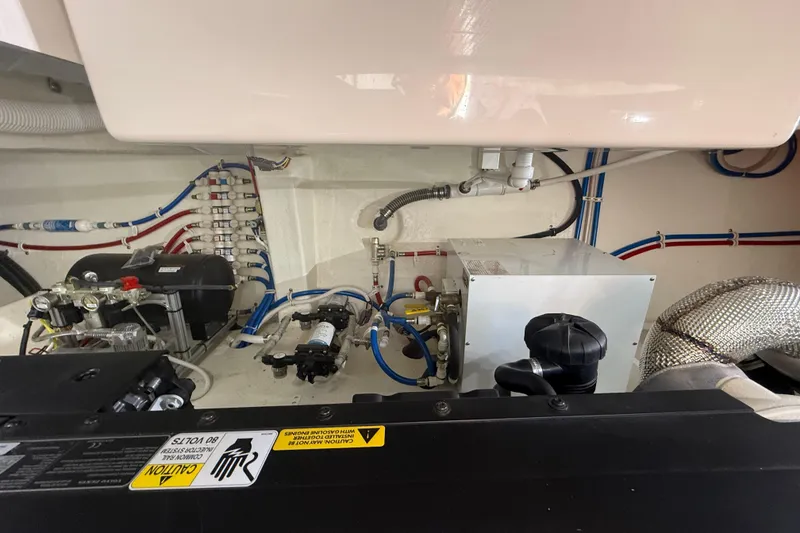Slide: The Image of Engine room of 2019 Tiara Yachts C44 Coupe, showcasing mechanical components and wiring. - 43