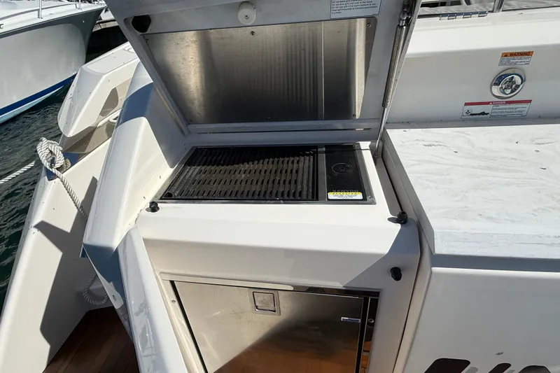 Slide: The Image of Outdoor grill on 2019 Tiara Yachts C44 Coupe, docked by the water. - 8