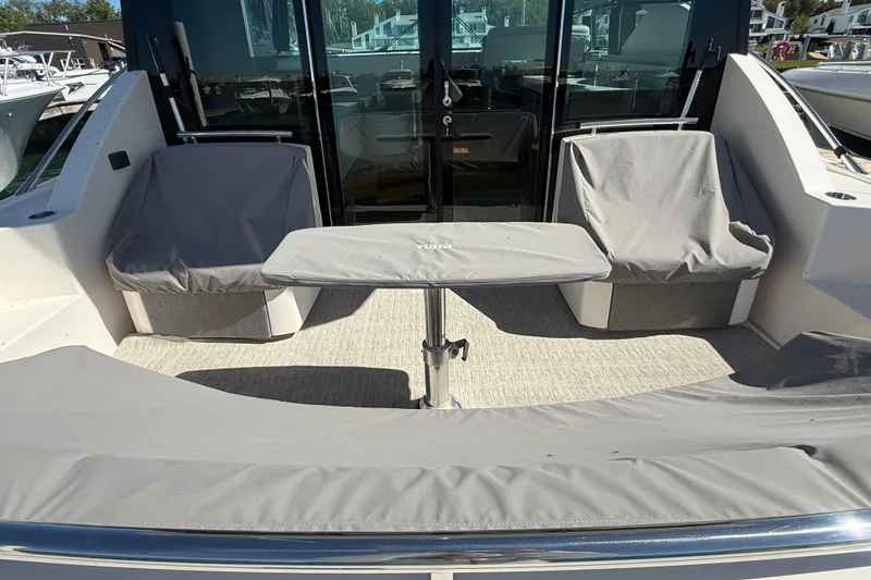 Slide: The Image of 2019 Tiara Yachts C44 Coupe cockpit with covered seating and table. - 9