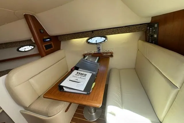 Slide: The Image of Interior of 2001 Tiara Yachts 2900 Open with beige seating and wooden table. - 16