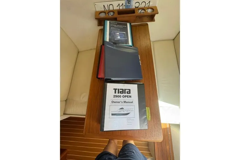 Slide: The Image of Owner's manuals on a wooden table inside a 2001 Tiara Yachts 2900 Open. - 17