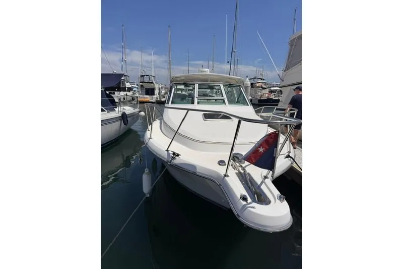Slide: The Image of 2001 Tiara Yachts 2900 Open docked at marina, featuring sleek design and nautical flag. - 7