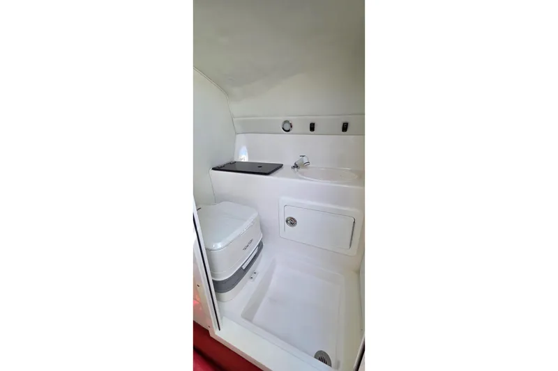 Slide: The Image of 2024 Velocity 290 Sport Cruiser bathroom with compact toilet and sink. - 12