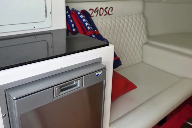 Slide: The Image of 2024 Velocity 290 Sport Cruiser interior with fridge and white seating. - 9
