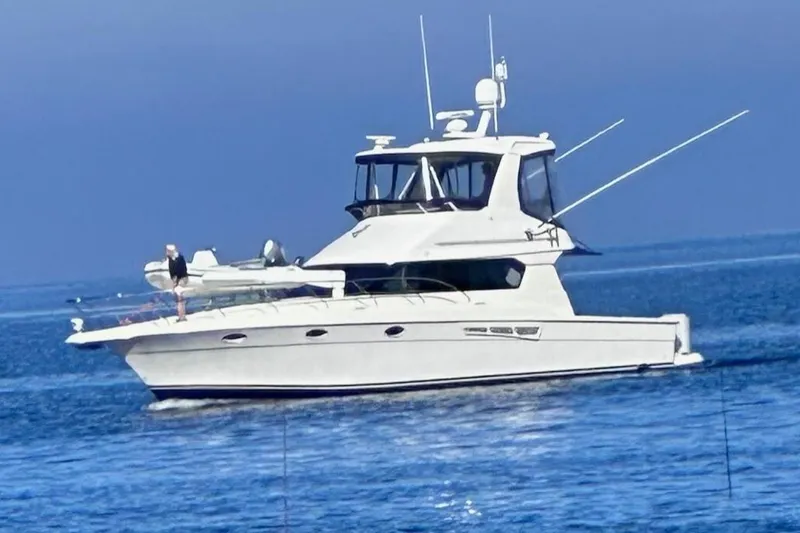 The Image of A 2000 Silverton 42 Convertible yacht cruising on calm blue waters. - 0