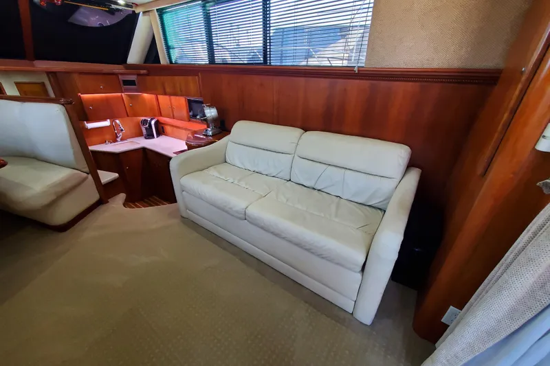 Slide: The Image of Interior of 2000 Silverton 42 Convertible yacht with white sofa and wooden cabinetry. - 10