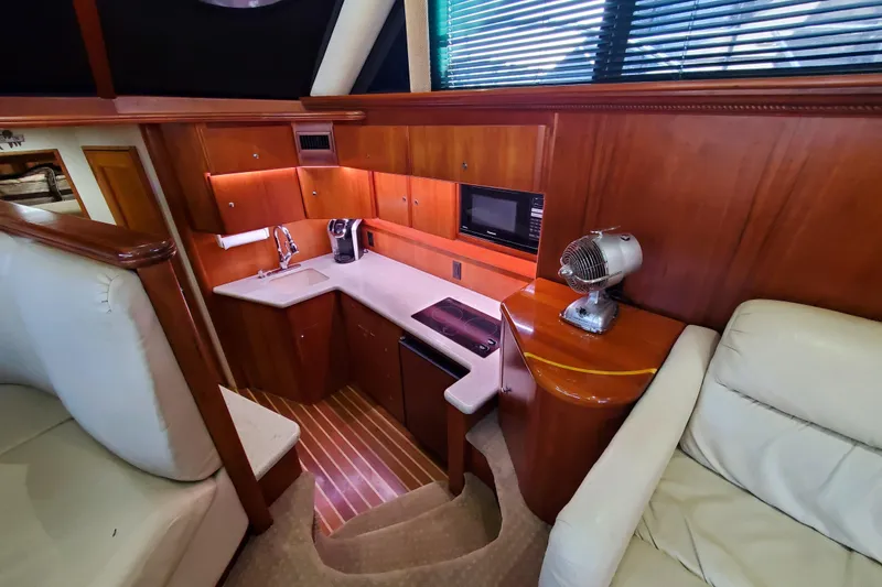 Slide: The Image of Interior of 2000 Silverton 42 Convertible yacht with compact kitchen and seating area. - 13