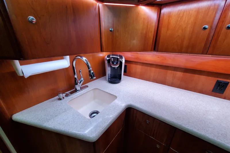 Slide: The Image of Luxurious kitchen area in a 2000 Silverton 42 Convertible yacht with wooden cabinets and modern fixtures. - 15