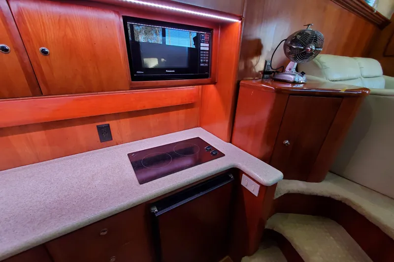 Slide: The Image of Interior of 2000 Silverton 42 Convertible yacht kitchen with stove, microwave, and fan. - 16