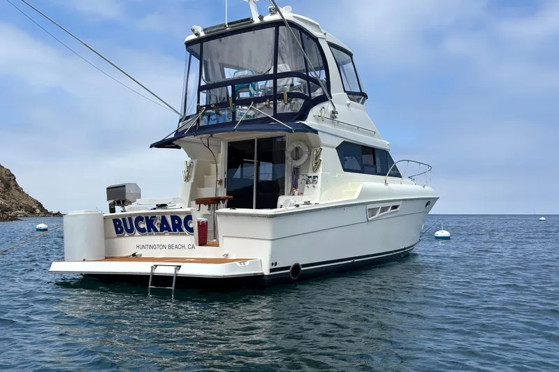 Slide: The Image of 2000 Silverton 42 Convertible yacht anchored in calm waters, Huntington Beach, CA. - 2