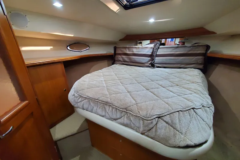 Slide: The Image of Cozy cabin interior of 2000 Silverton 42 Convertible yacht with plush bedding. - 20