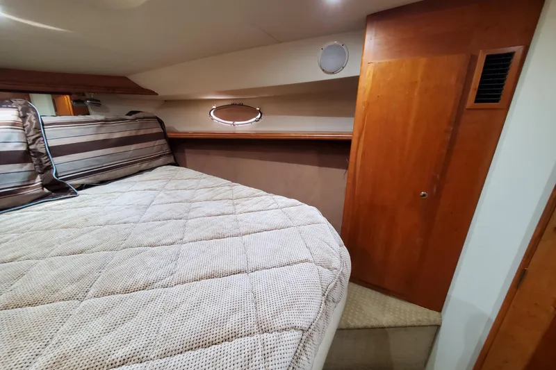 Slide: The Image of Interior cabin of a 2000 Silverton 42 Convertible yacht with cozy bedding and wooden accents. - 21