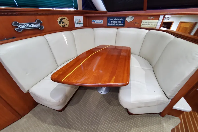 Slide: The Image of Luxurious dining area in a 2000 Silverton 42 Convertible yacht with plush seating and wooden table. - 24
