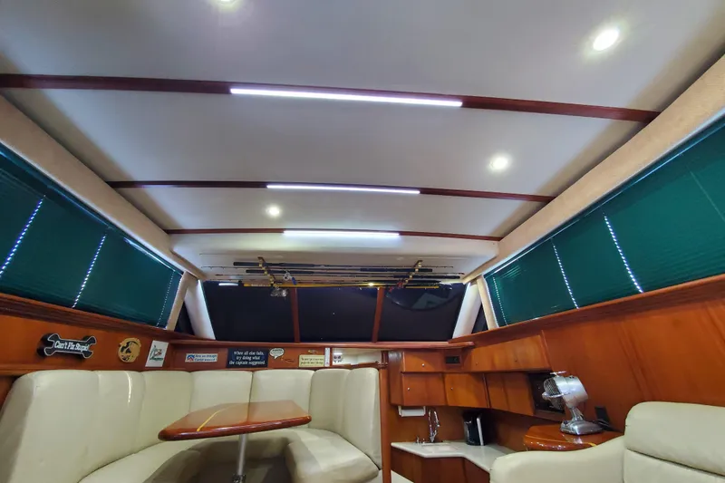 Slide: The Image of Interior of a 2000 Silverton 42 Convertible yacht with seating and wooden cabinetry. - 25