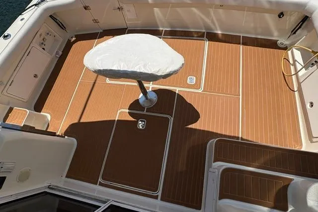Slide: The Image of Cockpit of 2000 Silverton 42 Convertible yacht with teak flooring and covered pedestal table. - 27