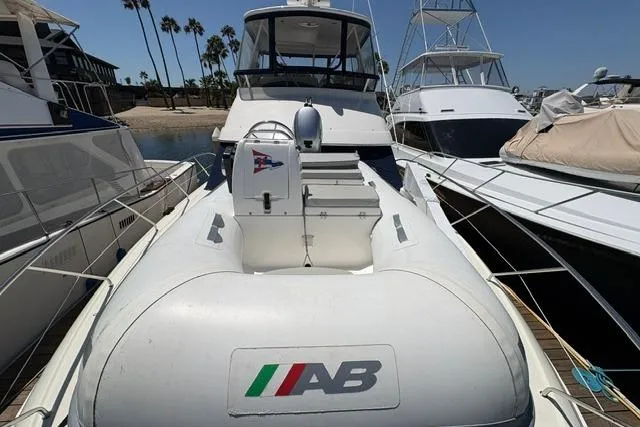Slide: The Image of 2000 Silverton 42 Convertible yacht docked with inflatable tender on deck. - 35