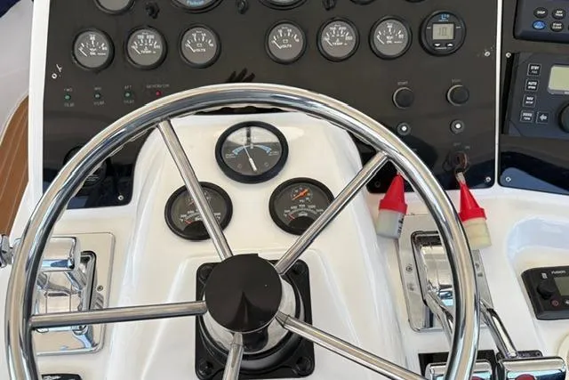 Slide: The Image of Control panel of a 2000 Silverton 42 Convertible boat with steering wheel and gauges. - 36