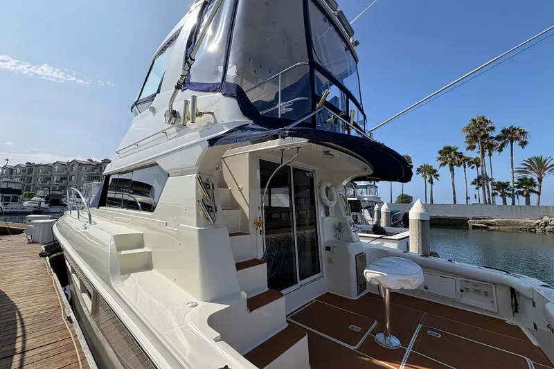 Slide: The Image of 2000 Silverton 42 Convertible yacht docked at marina with palm trees in background. - 4