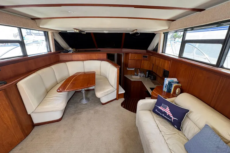 Slide: The Image of Interior of 2000 Silverton 42 Convertible yacht with cozy seating and elegant wood finishes. - 42