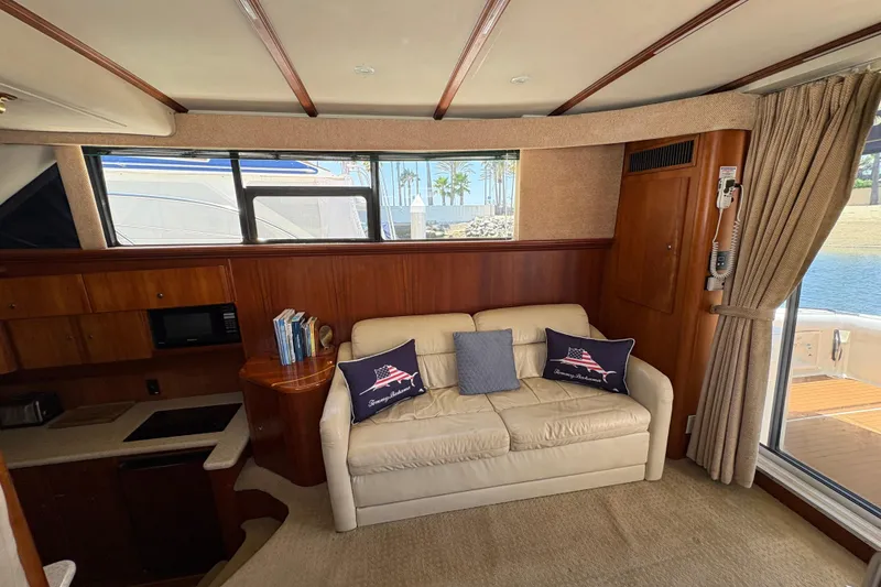Slide: The Image of Interior of 2000 Silverton 42 Convertible yacht with sofa, pillows, and kitchenette. - 43