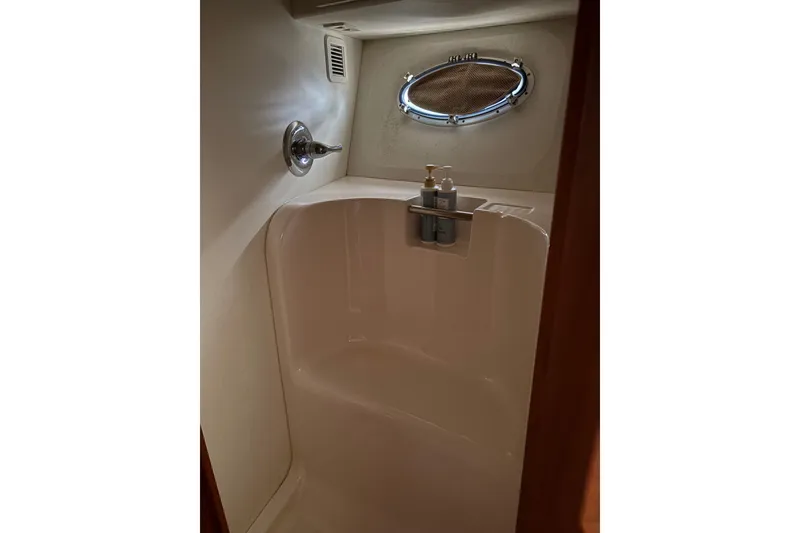 Slide: The Image of Shower area inside 2000 Silverton 42 Convertible yacht with porthole and toiletries. - 44