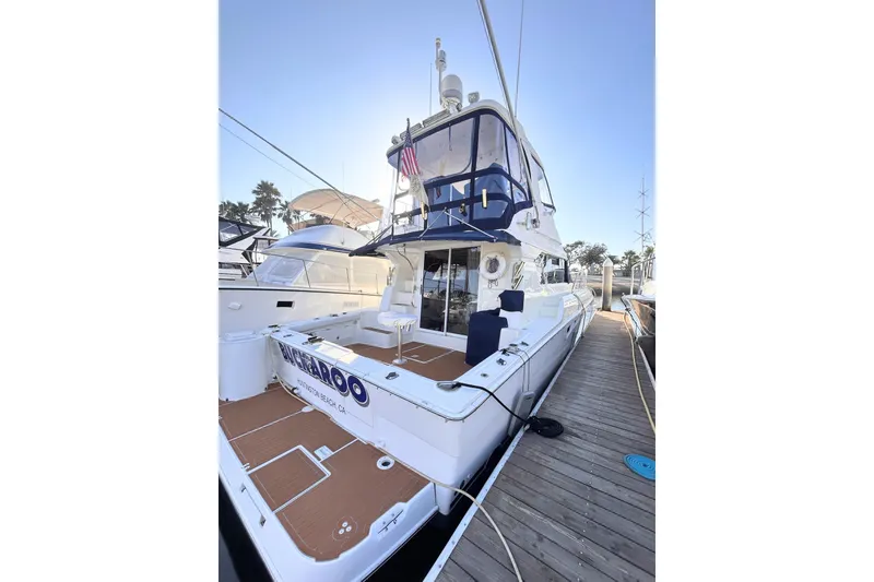 Slide: The Image of 2000 Silverton 42 Convertible yacht docked, featuring spacious deck and sleek design. - 51