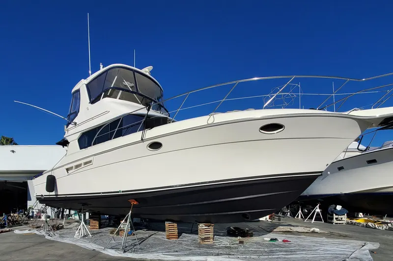 Slide: The Image of 2000 Silverton 42 Convertible yacht on dry dock under clear blue sky. - 6