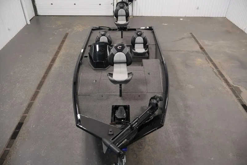 Slide: The Image of 2024 Crestliner XFC 179 fishing boat with seating and trolling motor in a garage. - 21